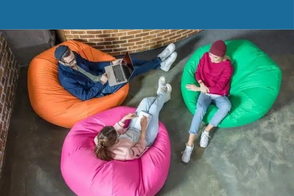 3 Leute sitzen auf Kissen in der Methodenwerkstatt.